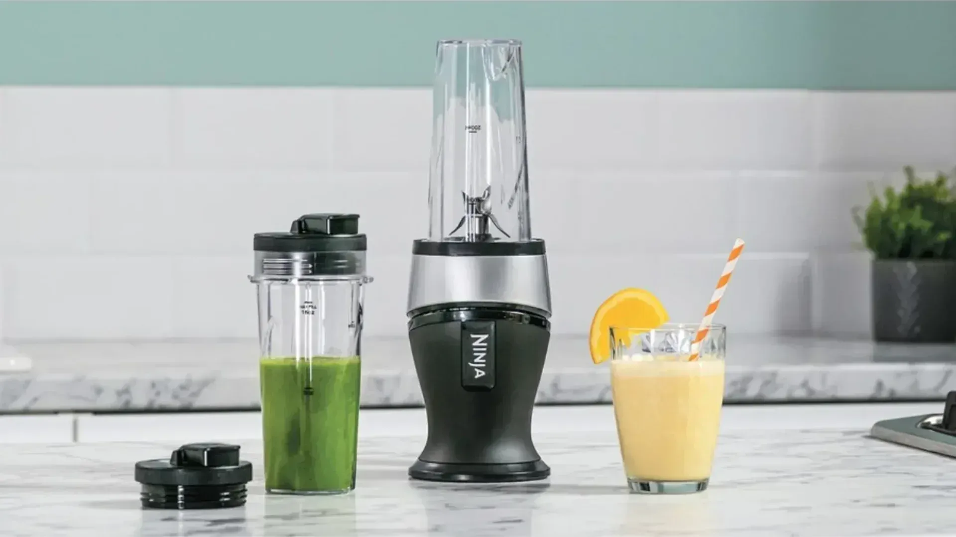 A Ninja blender next to a smoothie and a cocktail