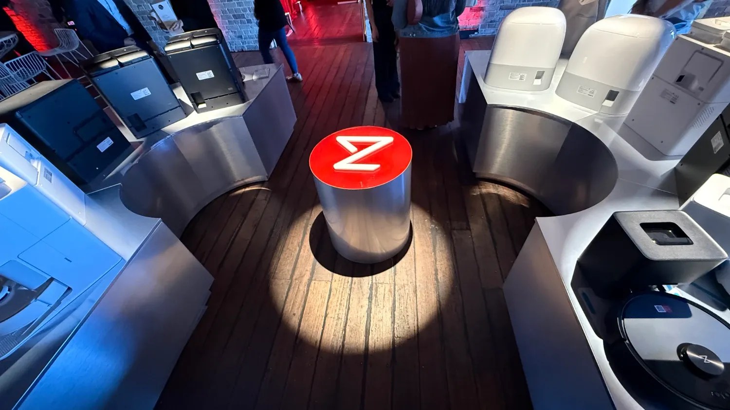 An image of a roborock logo on a metal bollard with robot vacuums around it and a spotlight on the logo. It's a weird photo.