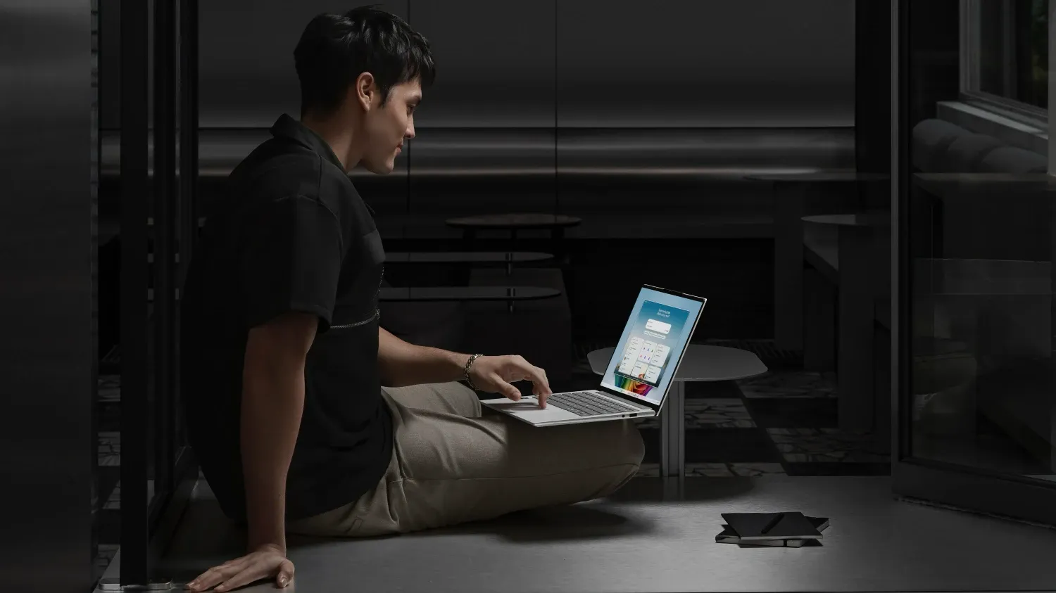 A man on the floor using the Swift Go in his lap