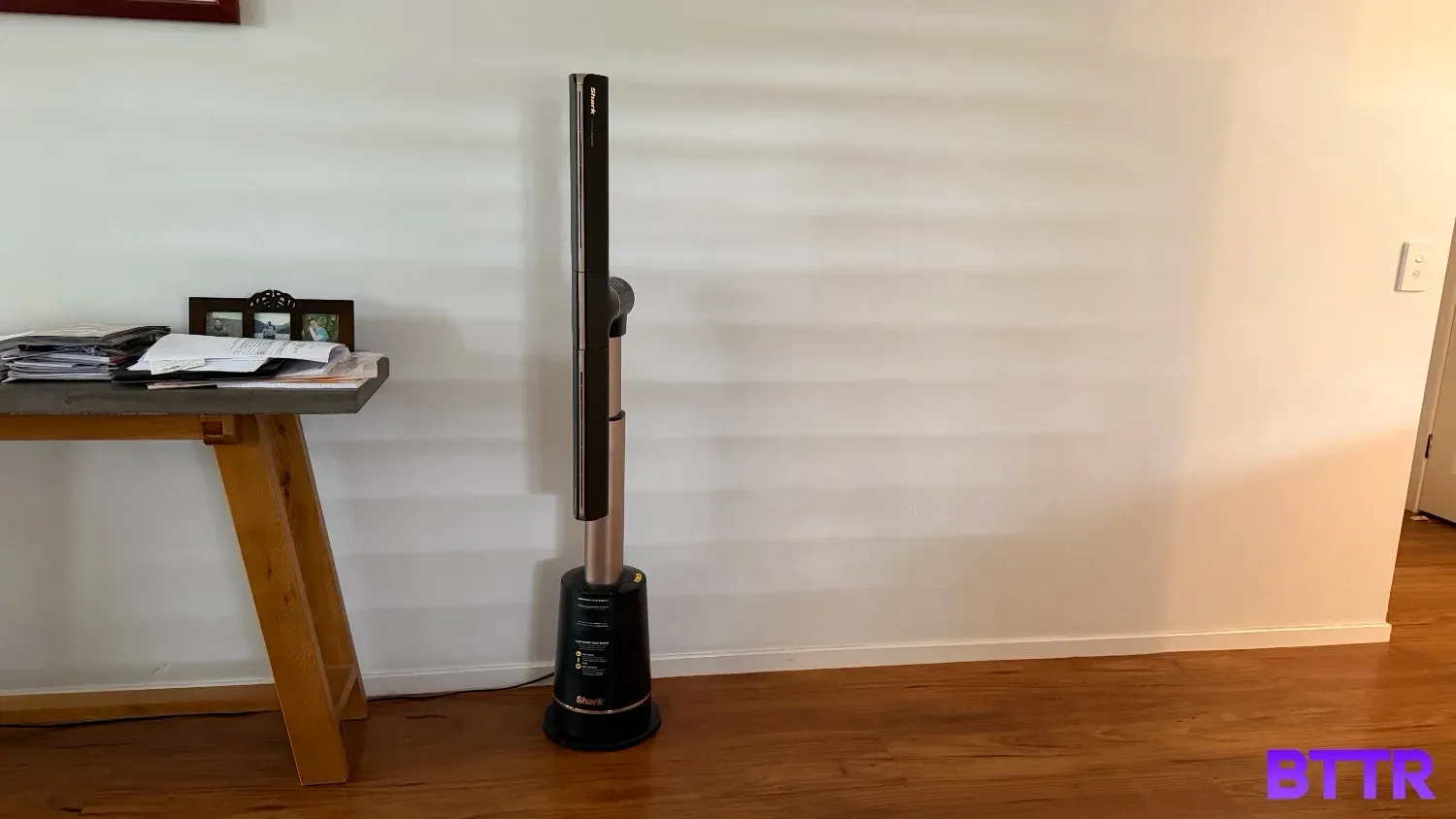 The Shark TurboBlade Ultra in tower mode agains a wall with filtered light behind