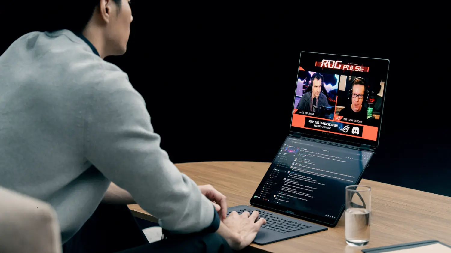 A man using the ROG Zephyrus Duo on a wooden desk