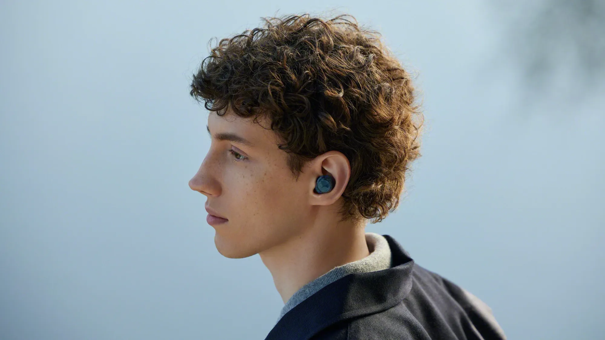 A young man waering the WF-C710N noise cancelling earbuds