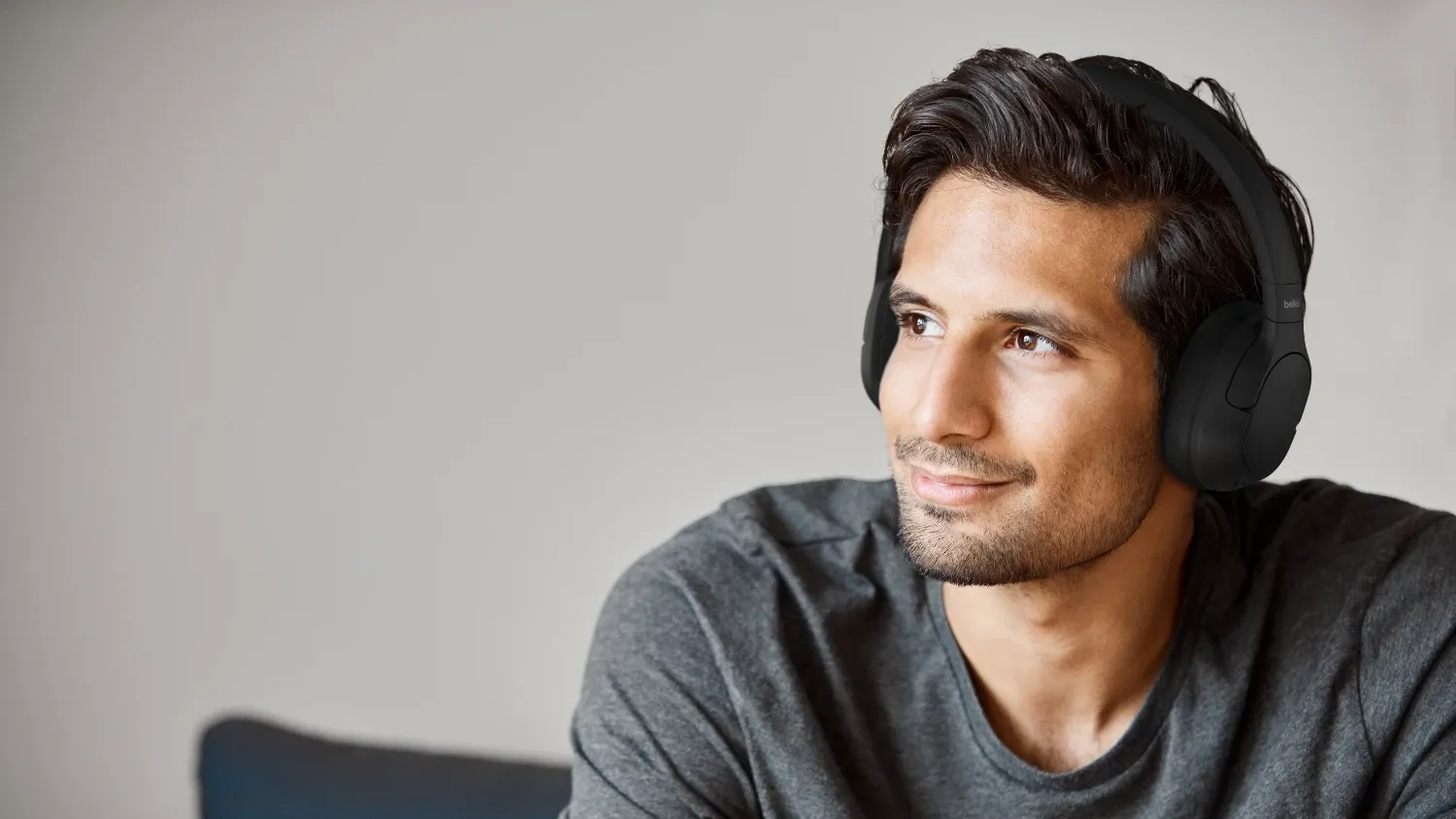 A man wearing the Belkin Isolate headphones, staring off into the distance 