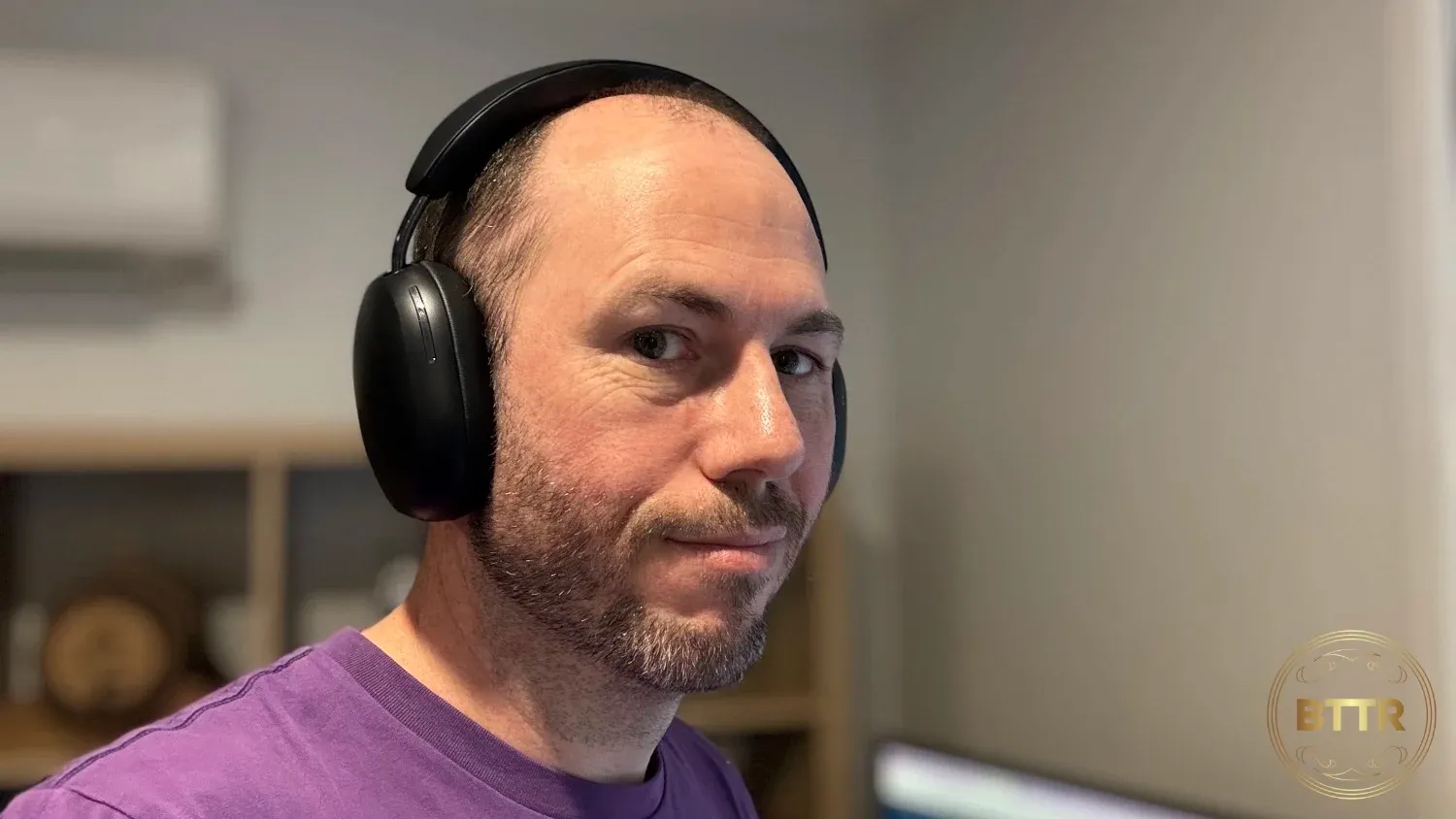 Me wearing the Sonos Ace black headphones and a purple shirt
