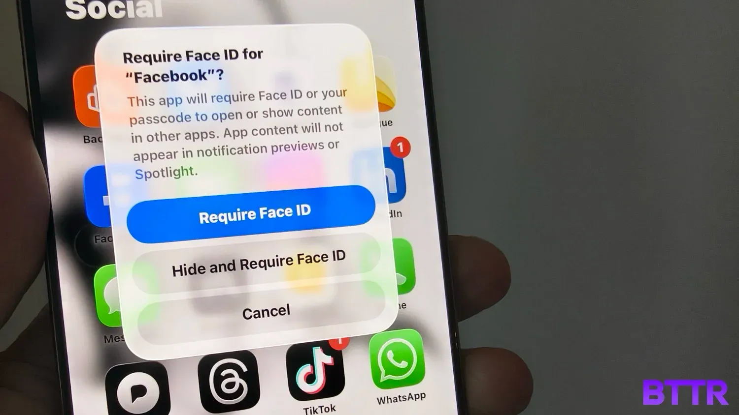 Close up of an iPhone with a message to require face ID to open Facebook