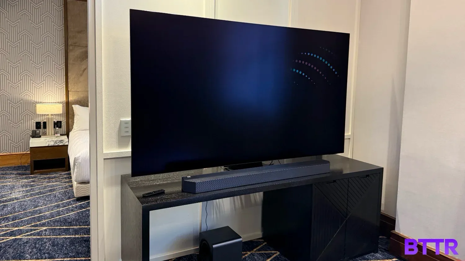 The Samsung S95F OLED set up in a bright hotel room, casually ignoring the glare