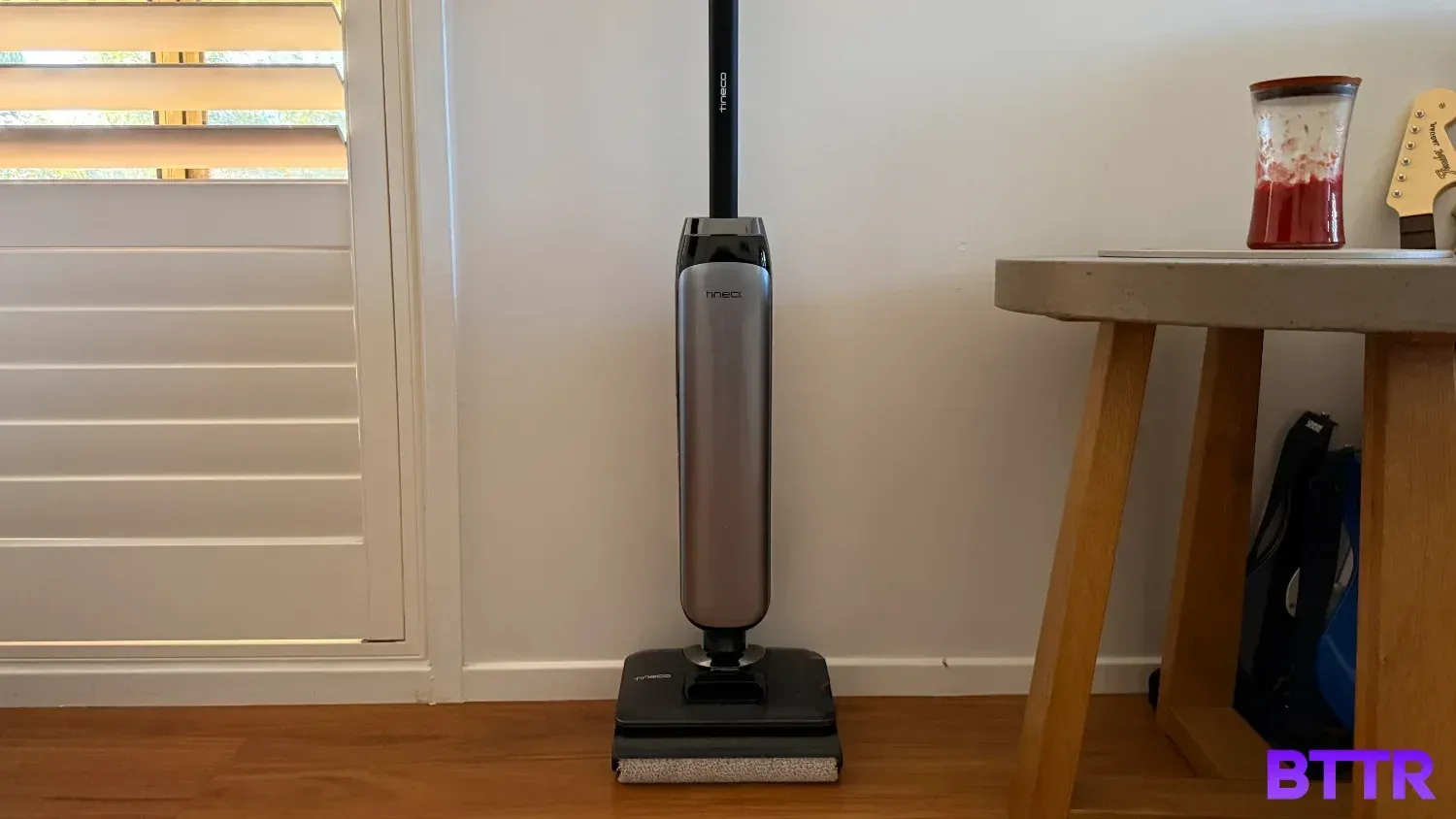 The Tineco Floor One S9 Artist Pro against a wall