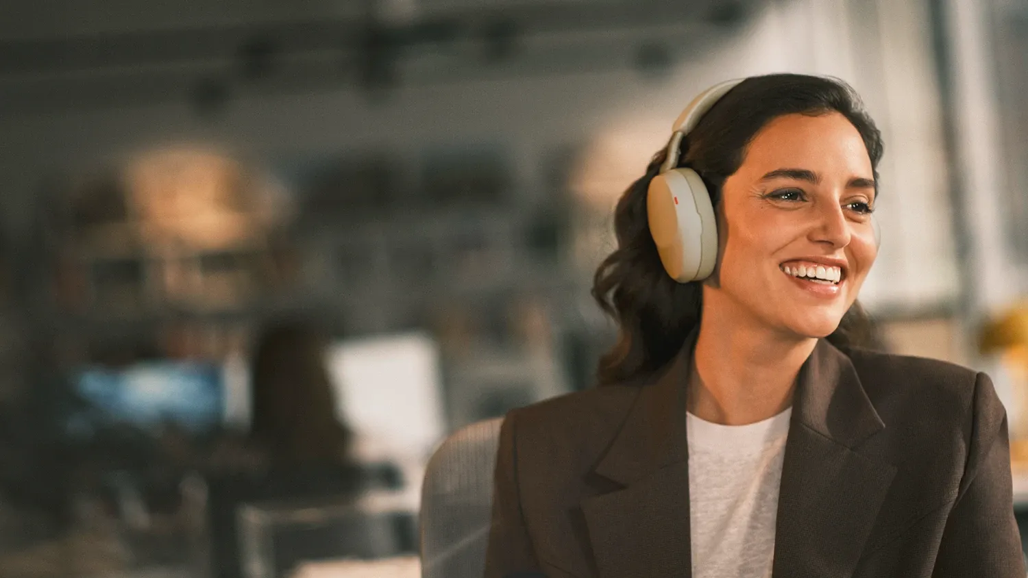 A woman in an office wearing the Jabra Evolve 85