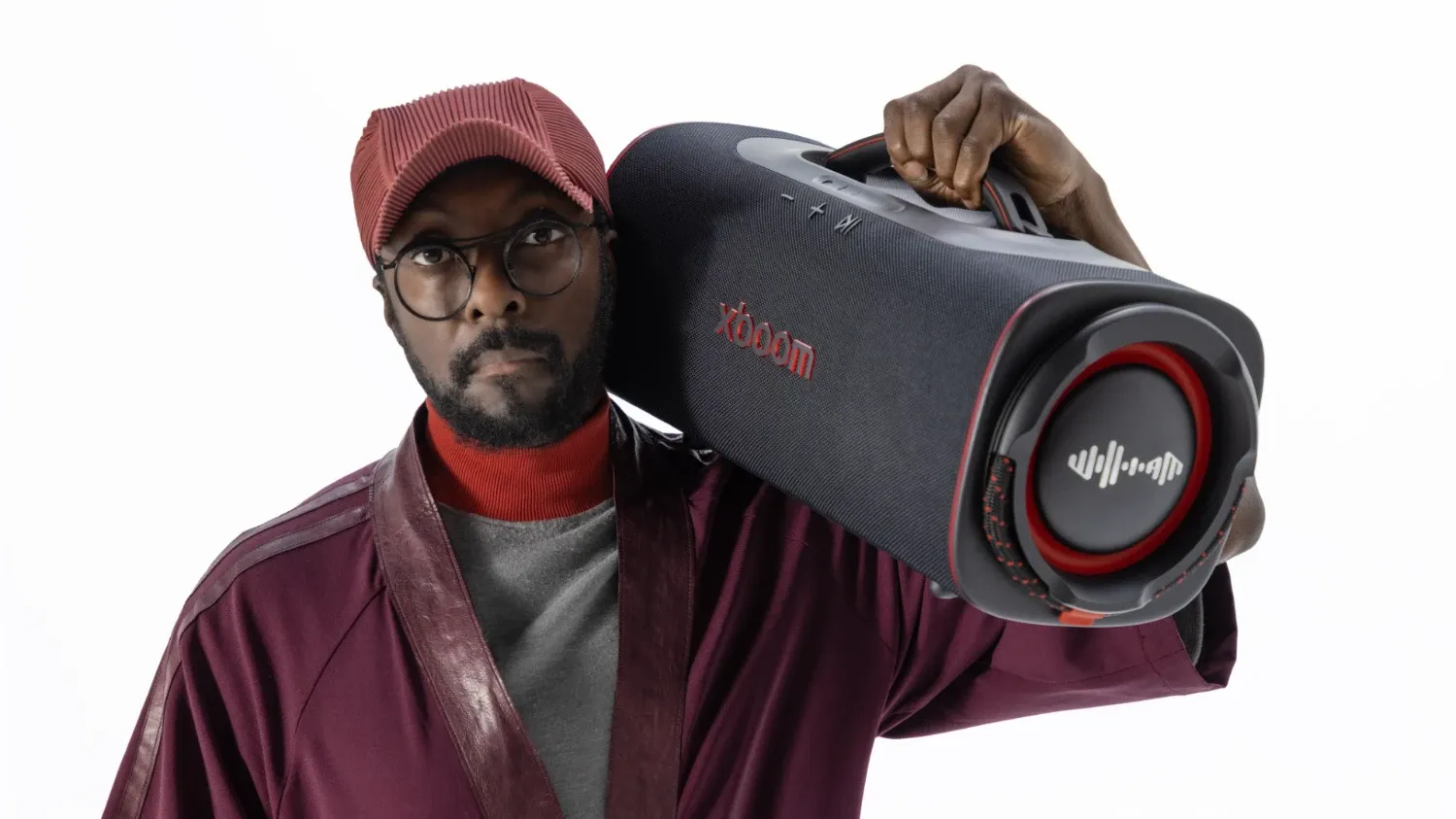 Will.I.Am holding one of the big xboom speakers over his shoulder