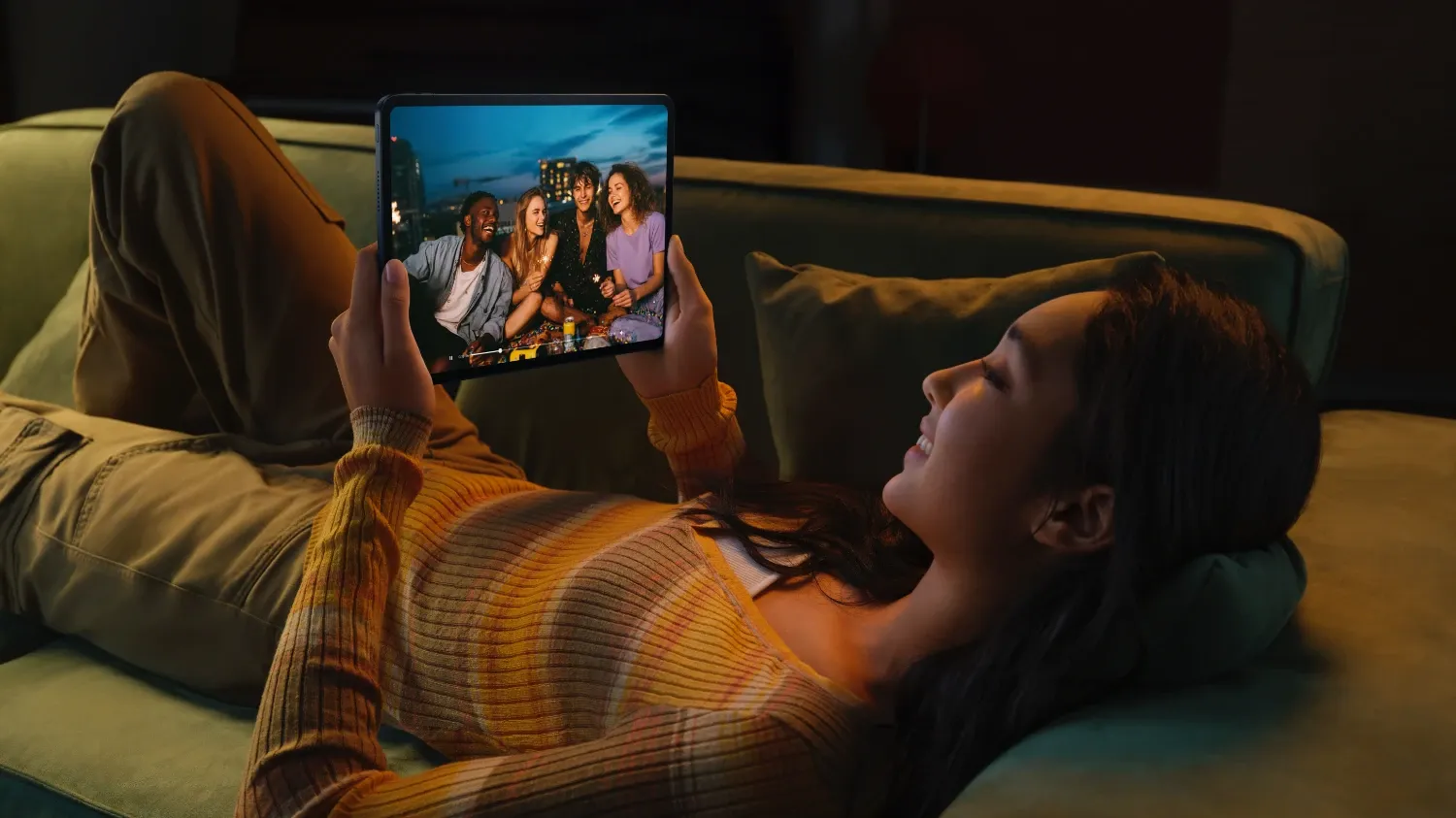 A girl on a couch on the Oppo Tablet watching a video