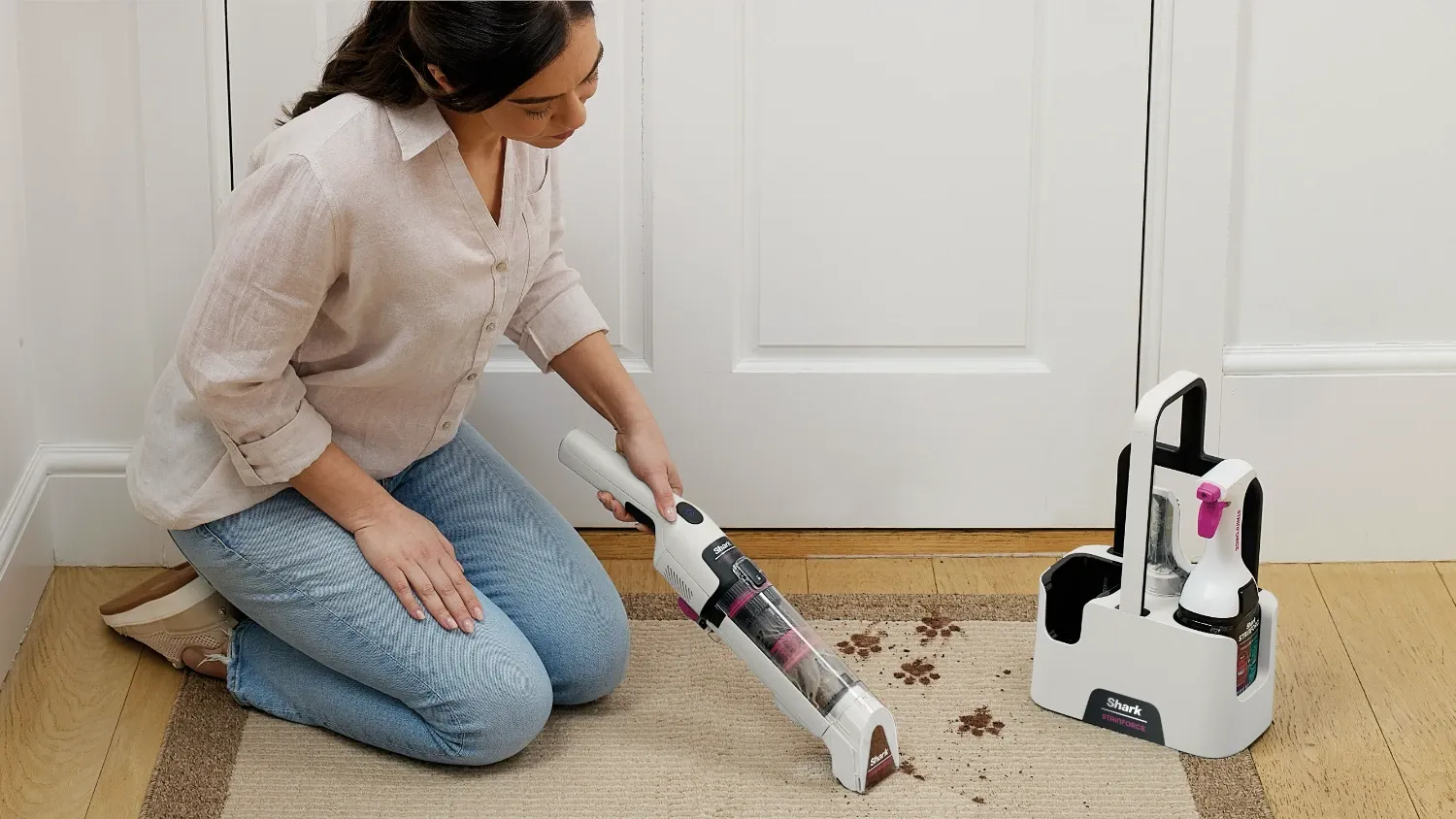 A woman using the StainForce on some pet footprints on a carpet inside