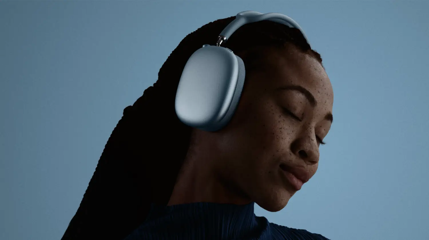 A woman wearing the blue AirPods Max 2