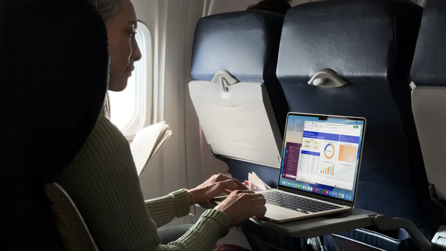 a woman on a plane with the new macbook air